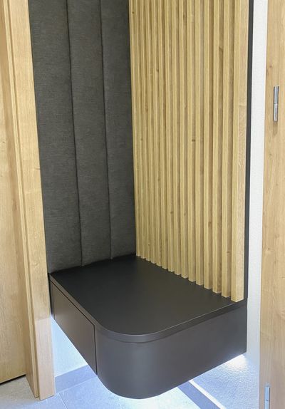 Detail čalouněné lavice v zádveří s dřevěnými lamelami